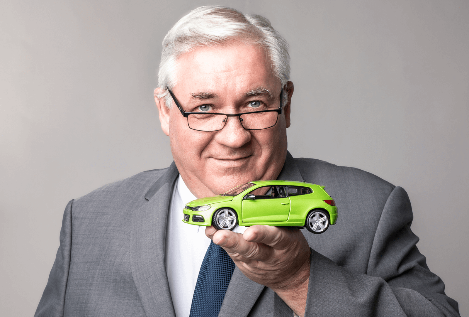 Directeur commercial de la marque Carpole Occasions tenant une voiture verte dans sa main