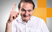 Expert comptable Cofif souriant levant sa main pour vous annoncer qu’il a une idée